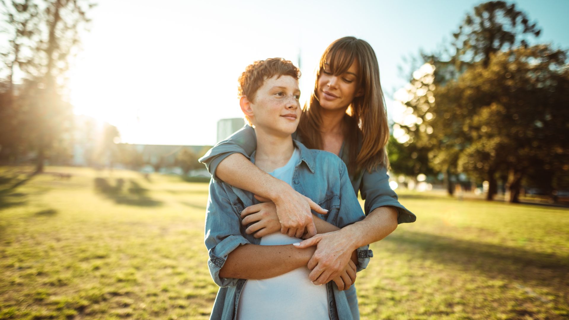 Woman embracing preteen child after having an expert-guided discussion regarding the preteen's gender identity