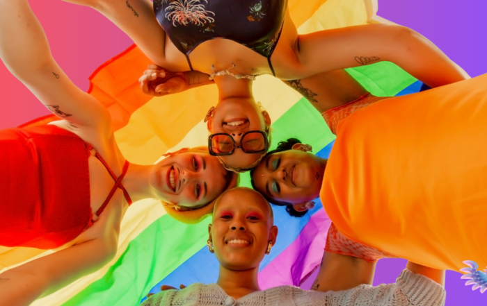 Trans and nonbinary teens encircling one another, expressing joy and fulfillment, because of their supportive families and communities